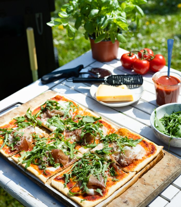 BBQ pizza met mozarella, ham, rucola en parmezaan