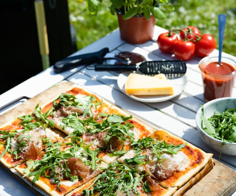 BBQ pizza met mozarella, ham, rucola en parmezaan